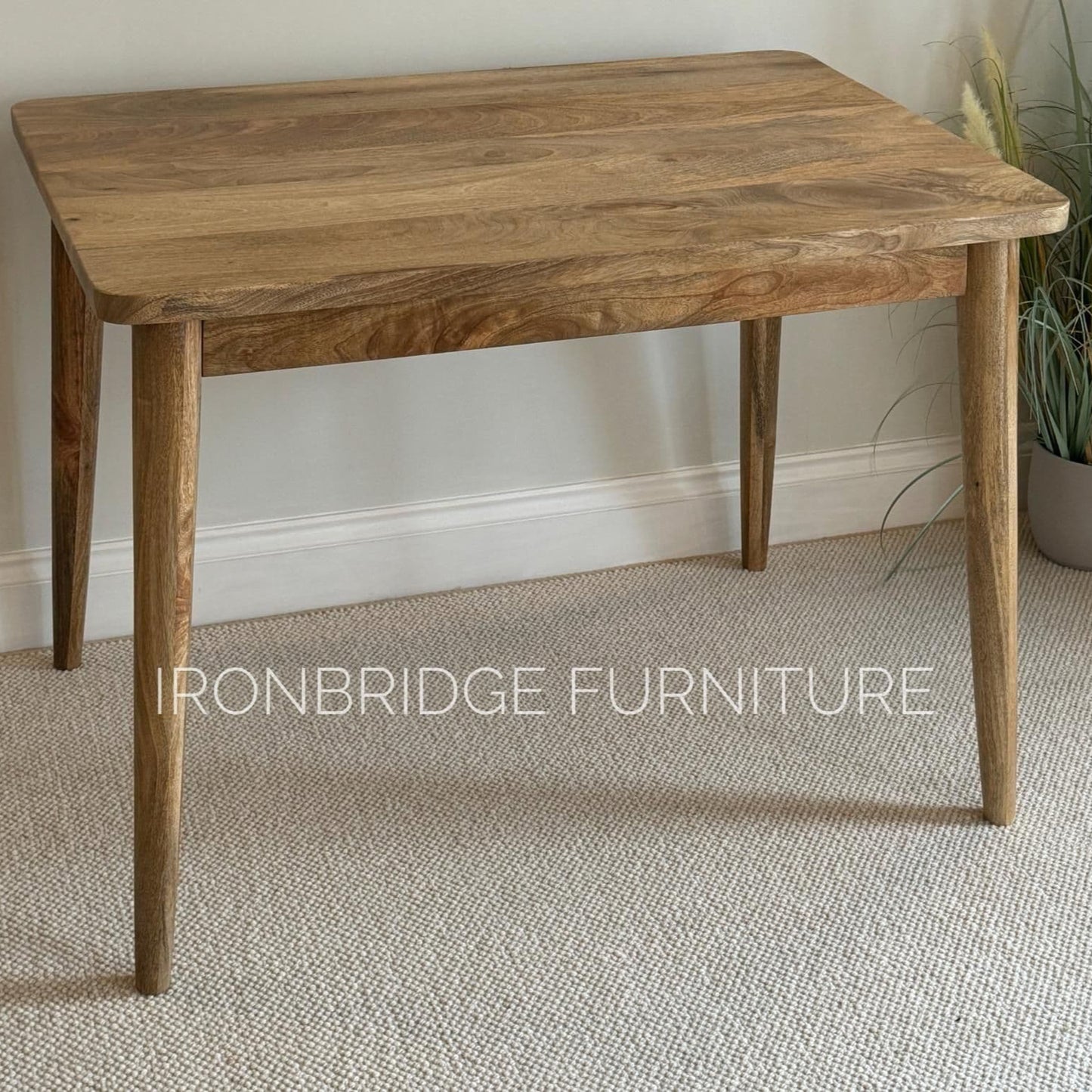 Just a 100 x 70cmSquare Mango dining table with cone shaped legs in a dining room