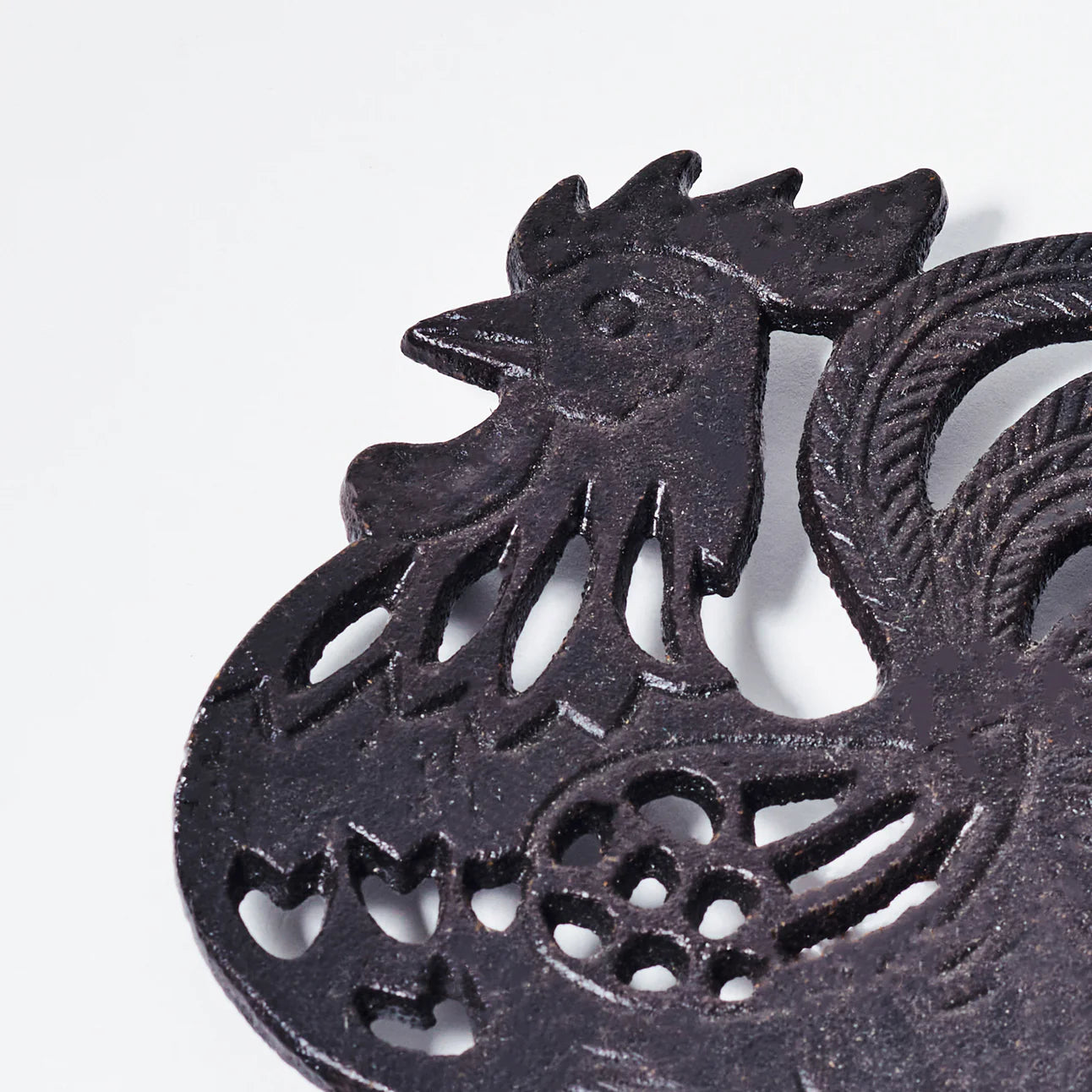 Black painted cast iron ROOSTER design trivet / hotplate - close up of rooster head