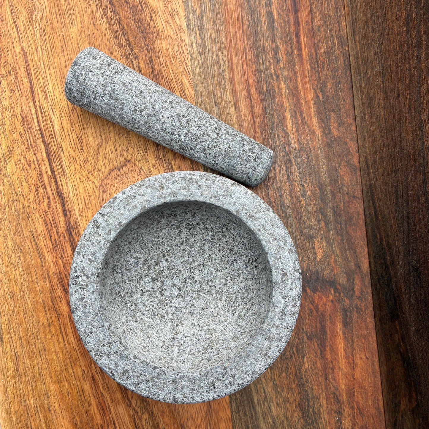 Stone mortar and pestle on a wooden surface