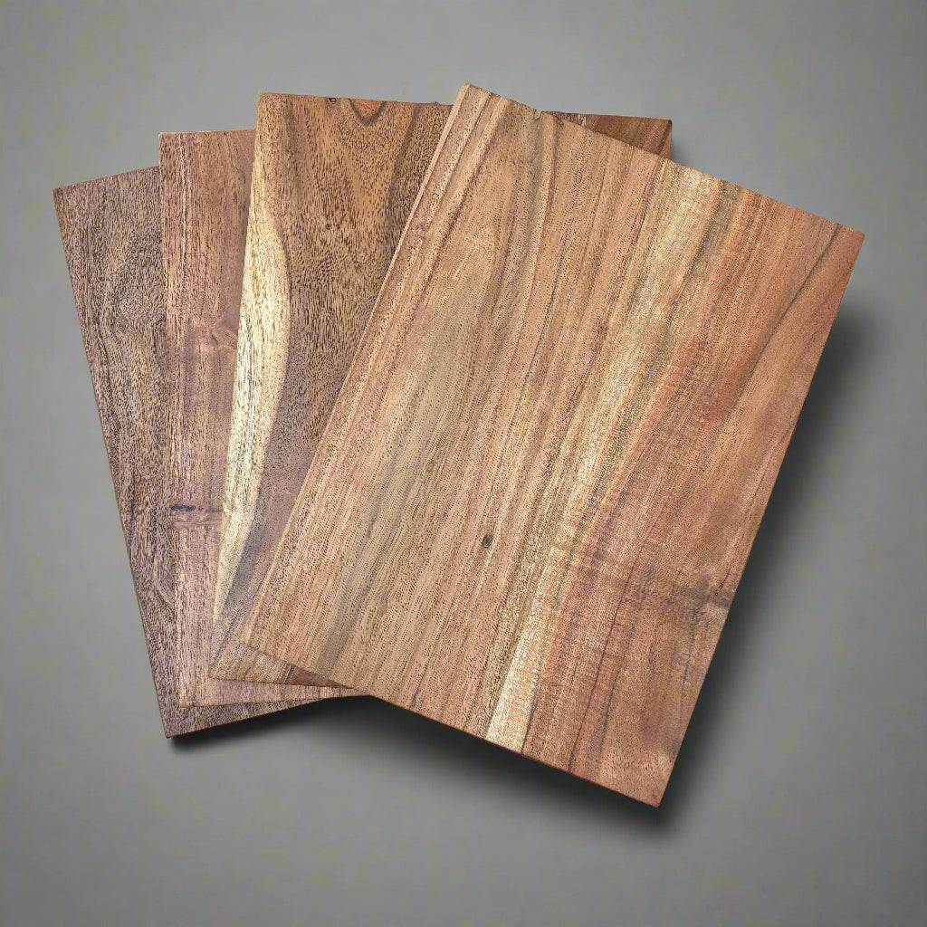 Four wooden cutting boards on a grey surface