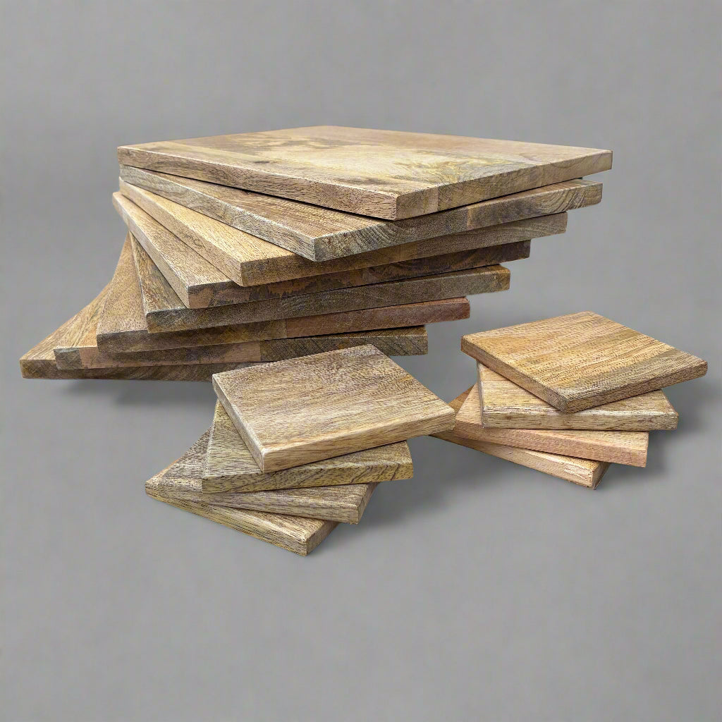 Stack of wooden placemats and coasters on a grey background.