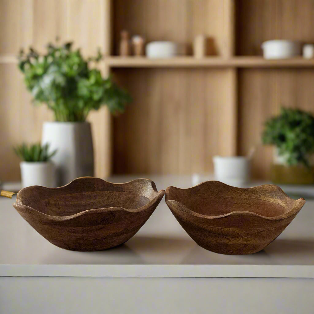 Two wooden bowls on a kitchen counter with a modern kitchen in the background.
