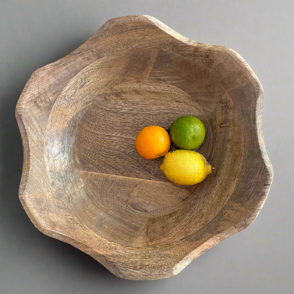 Wooden bowl with fruits on a wooden surface