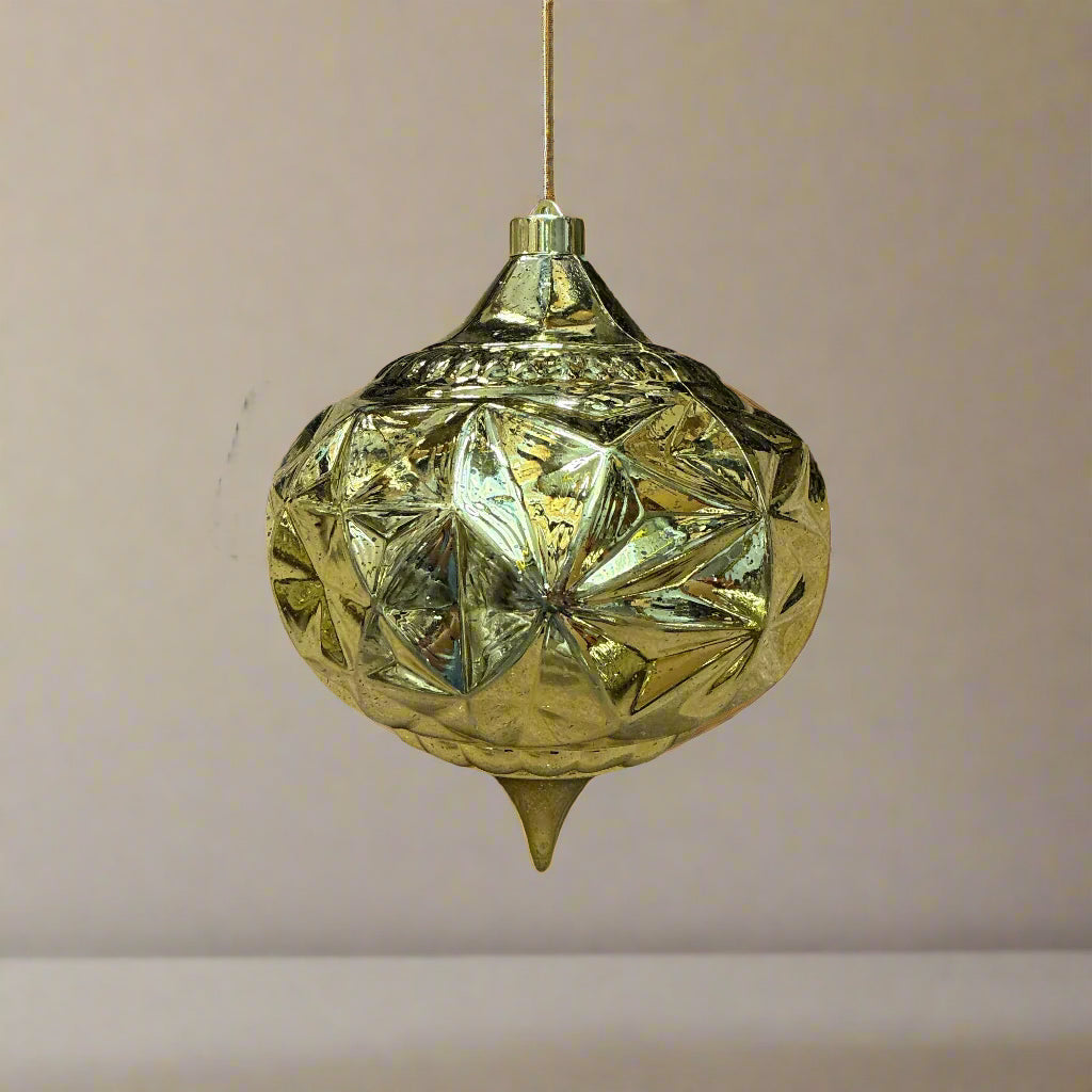 Decorative gold pendant light hanging against a neutral background