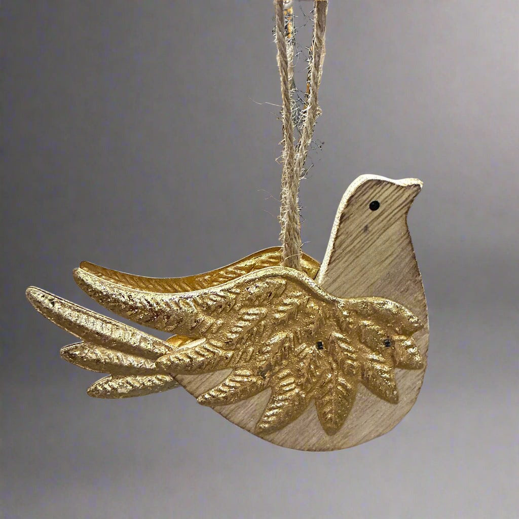 Wooden dove ornament with gold wings hanging in a warehouse setting