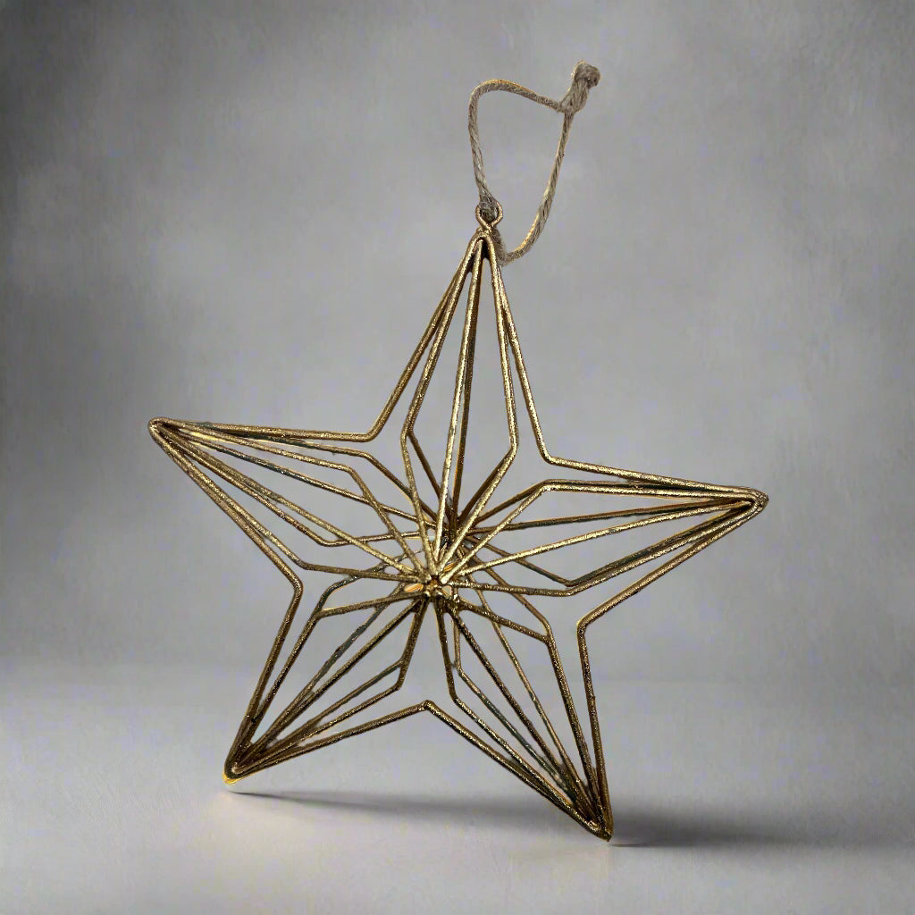 Gold geometric star ornament on a gray background