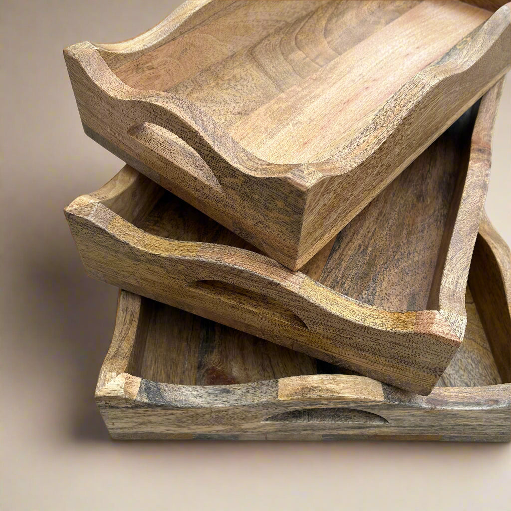 Stack of wooden trays on a light wood floor
