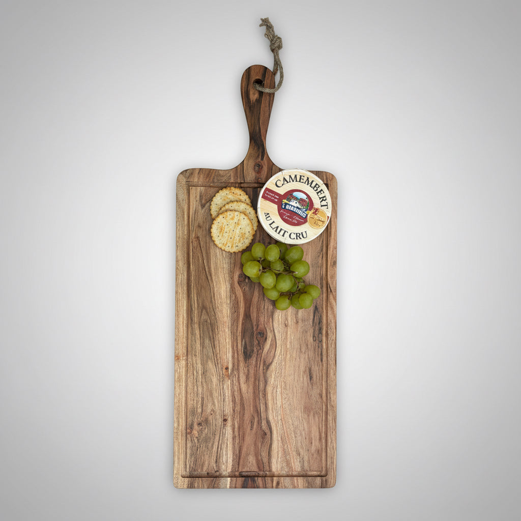Wooden cutting board with Camembert cheese, crackers, and grapes on a gray wooden floor.