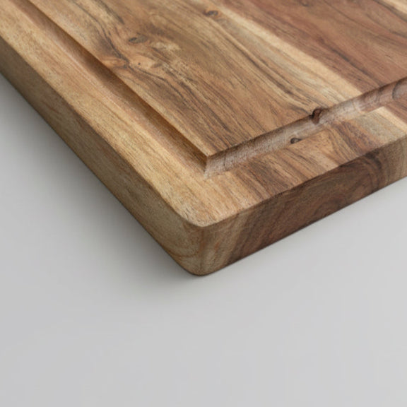 Wooden cutting board with a handle on a gray surface