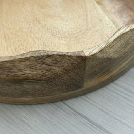 Close-up of a wooden bowl with a natural finish on a light gray surface