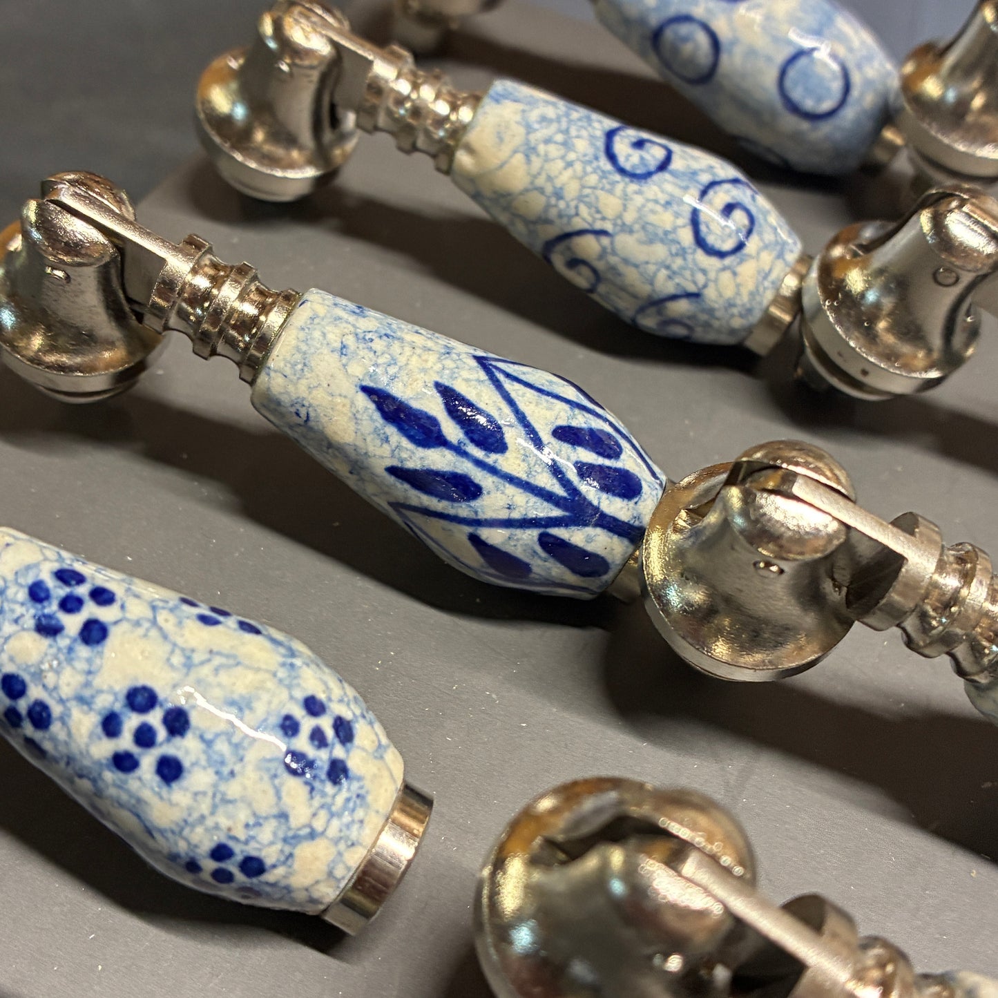 Close-up of a bracelet with blue and white patterned beads on a gray surface