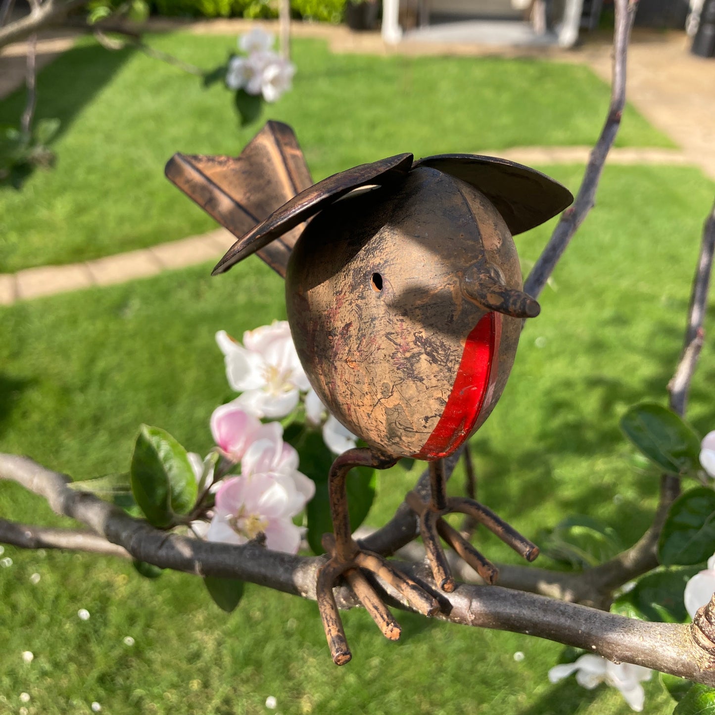 Tin robin garden ornament in tree