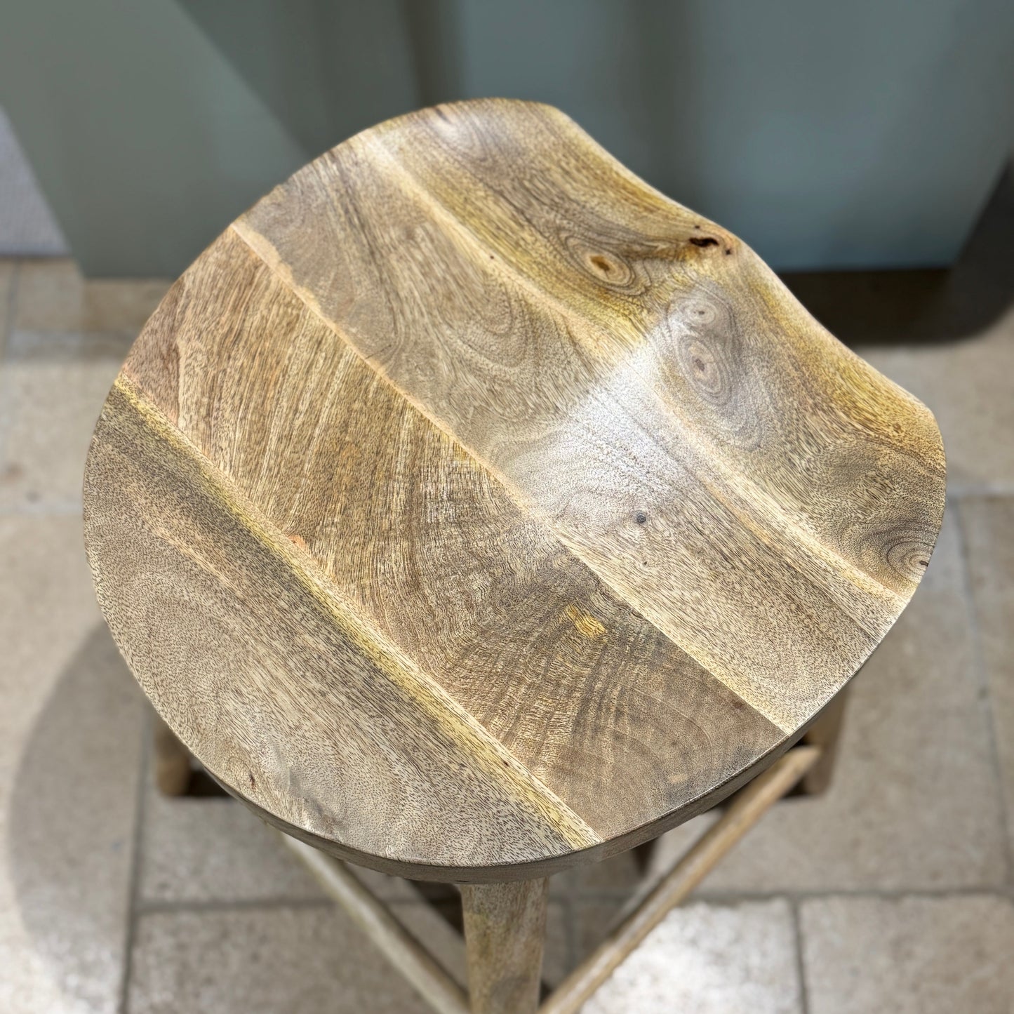 Mango wood bar stool with scalloped seat looking down from the top