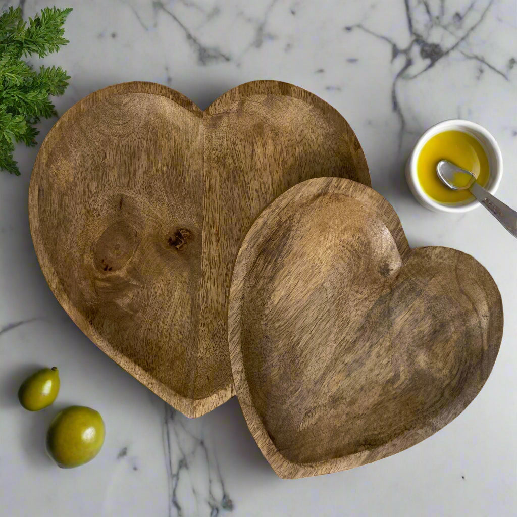 Hand carved solid Mango wood wooden heart dish/bowl on marble counter top.