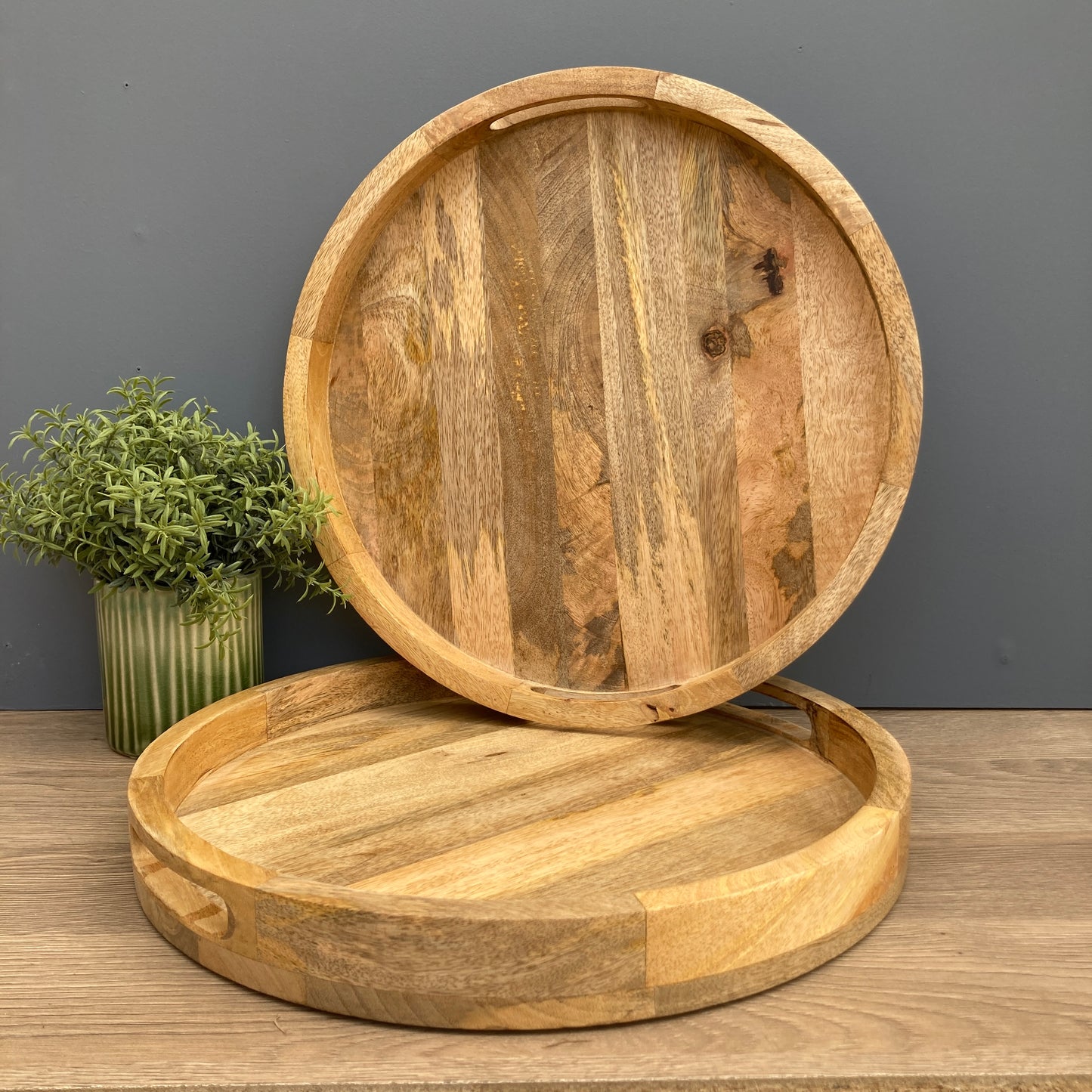 Pair of Solid Mango wooden round trays on a counter