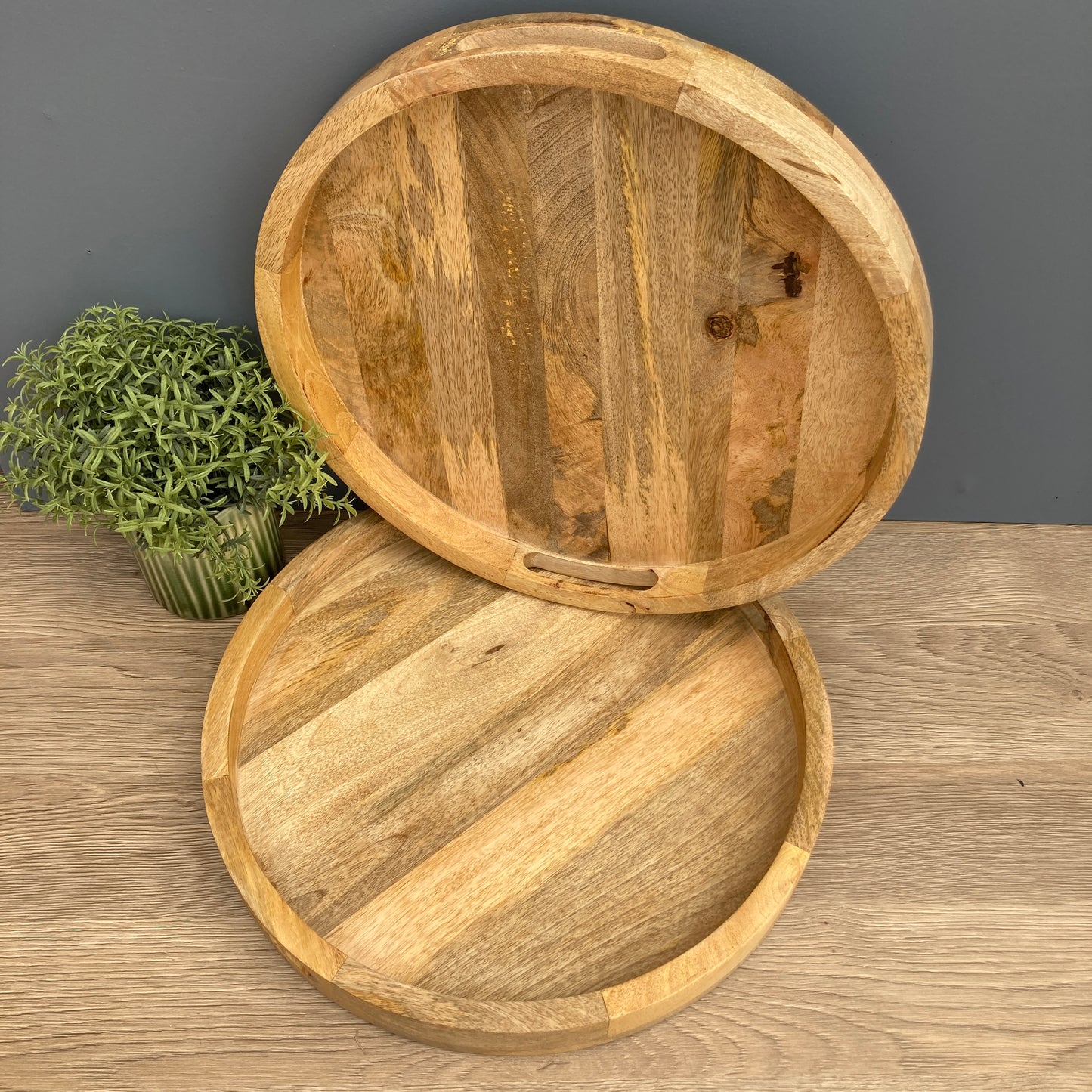 A pair of Solid Mango wooden round trays on a counter from above