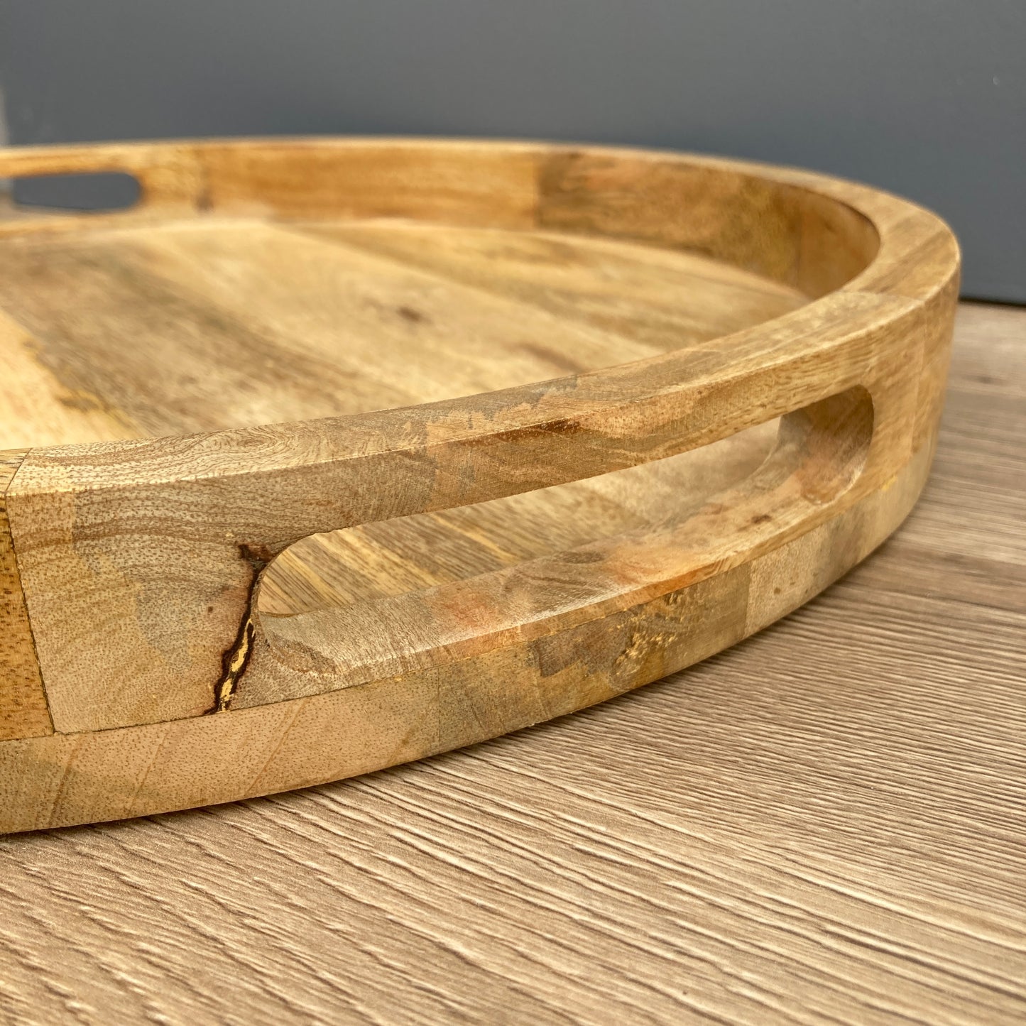 A close up Solid Mango wooden round tray