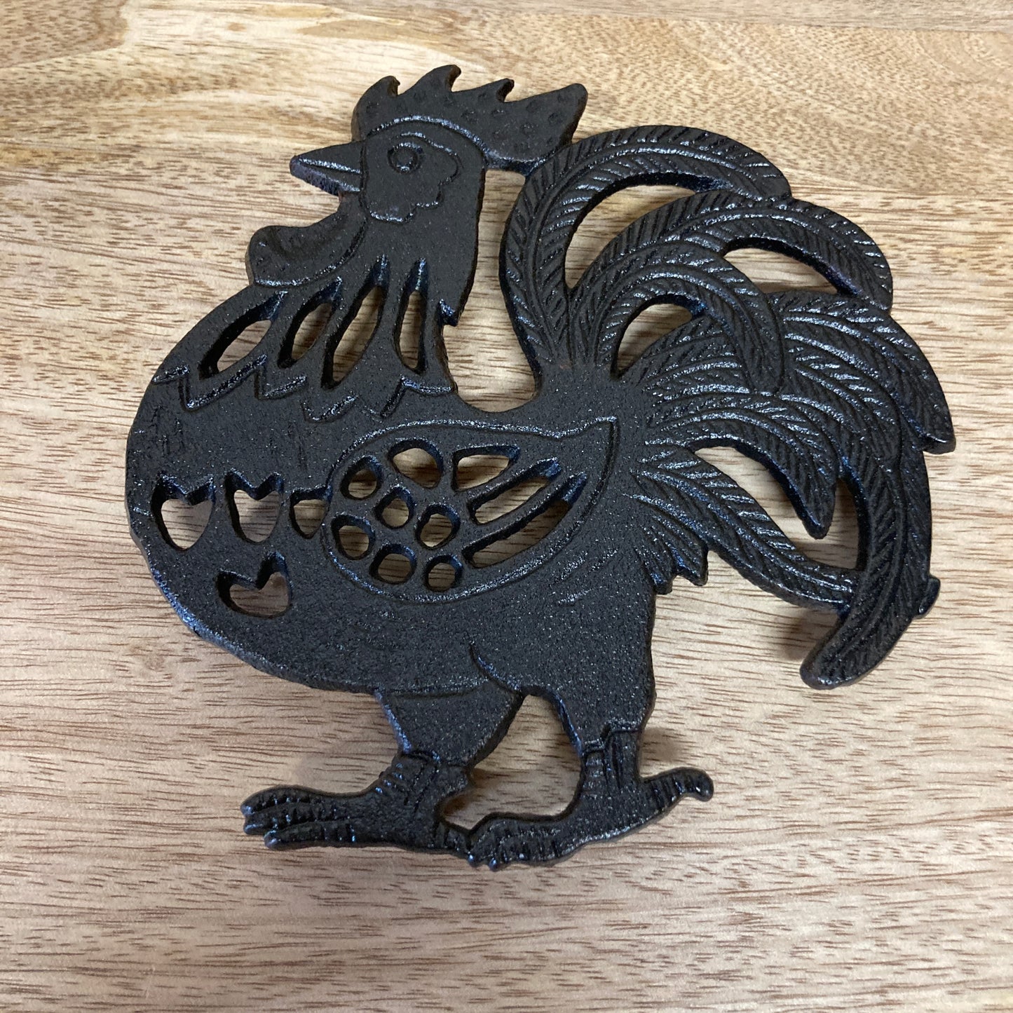 Black painted cast iron ROOSTER design trivet / hotplate - on table