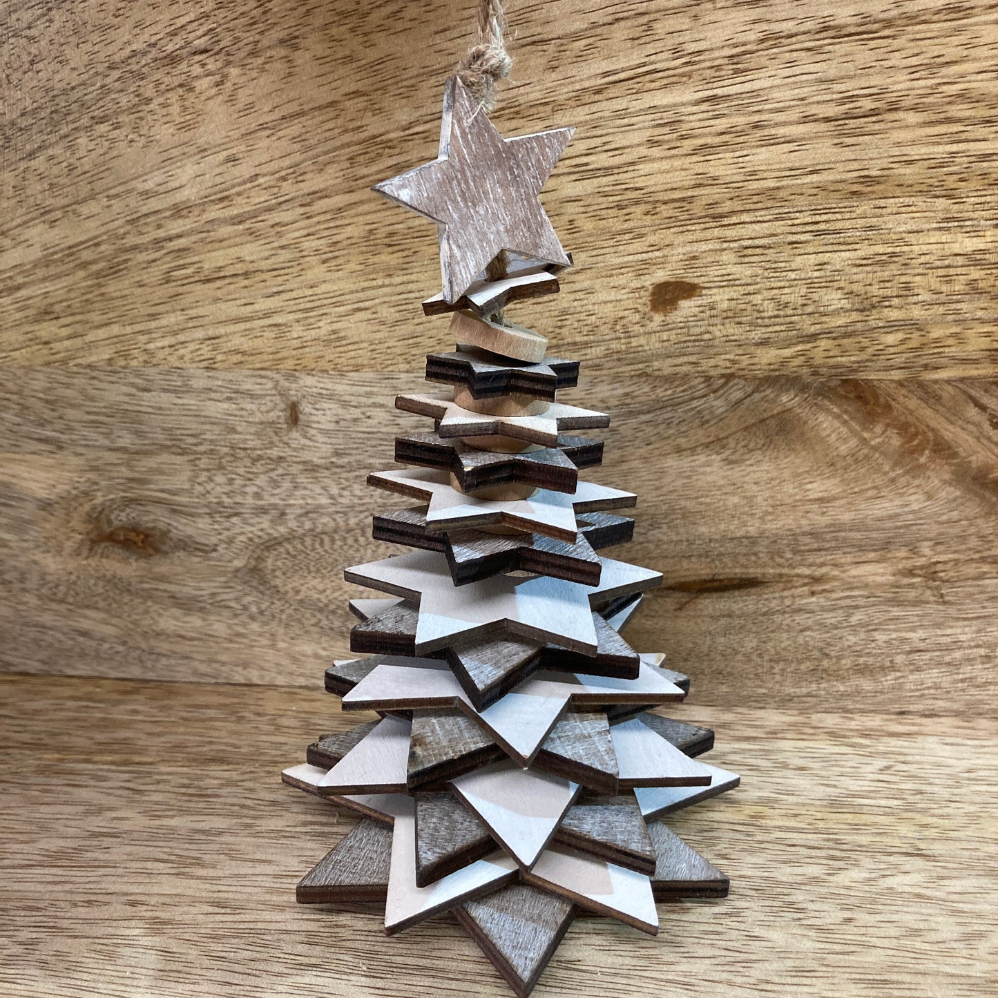 Wooden star Christmas trees - hanging above table.
