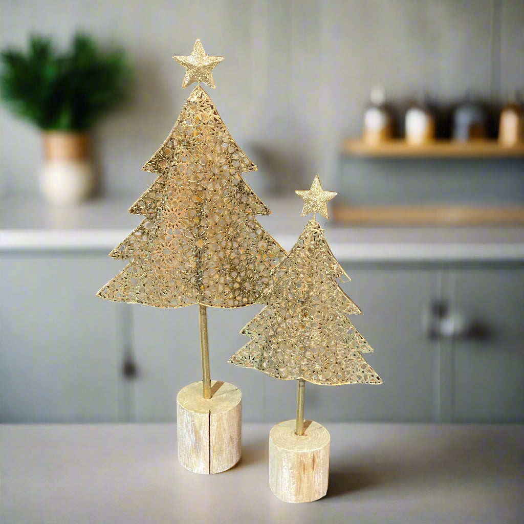 Gold metal Christmas tree on wood log base - both sizes shown displayed in a kitchen.