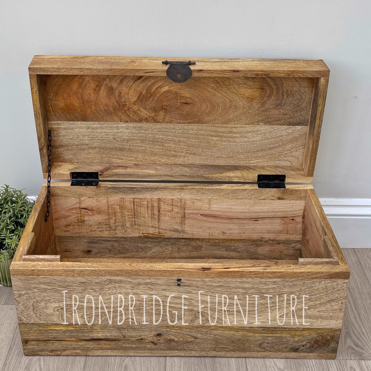Wooden storage chest with 'Ironbridge Furniture' branding on a light wooden floor.