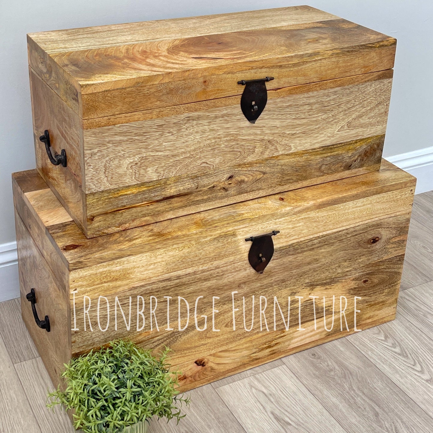 Two wooden storage trunks stacked on a light wood floor with 'Ironbridge Furniture' branding.