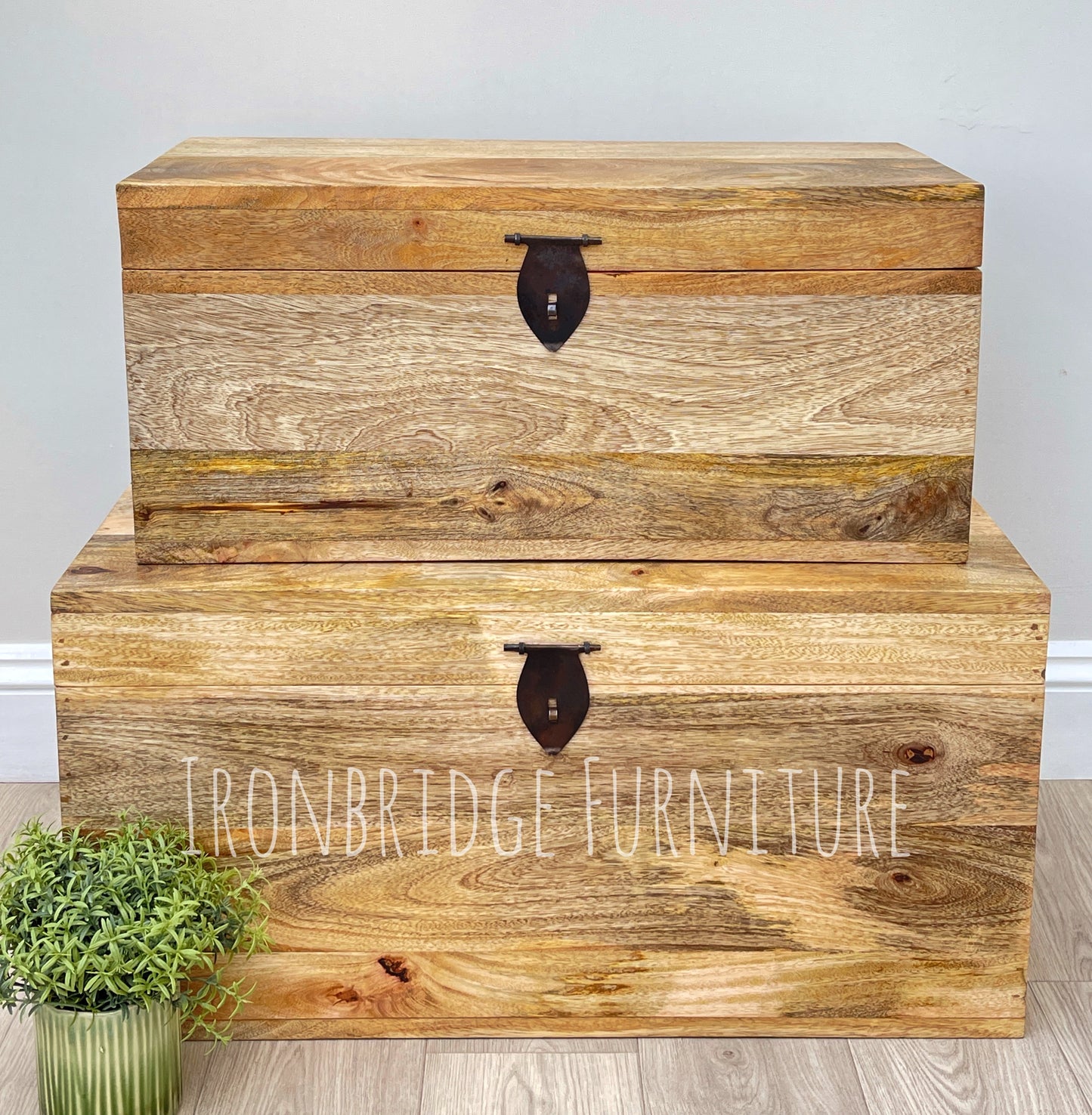Wooden storage trunks with 'Ironbridge Furniture' branding on a light wooden floor.