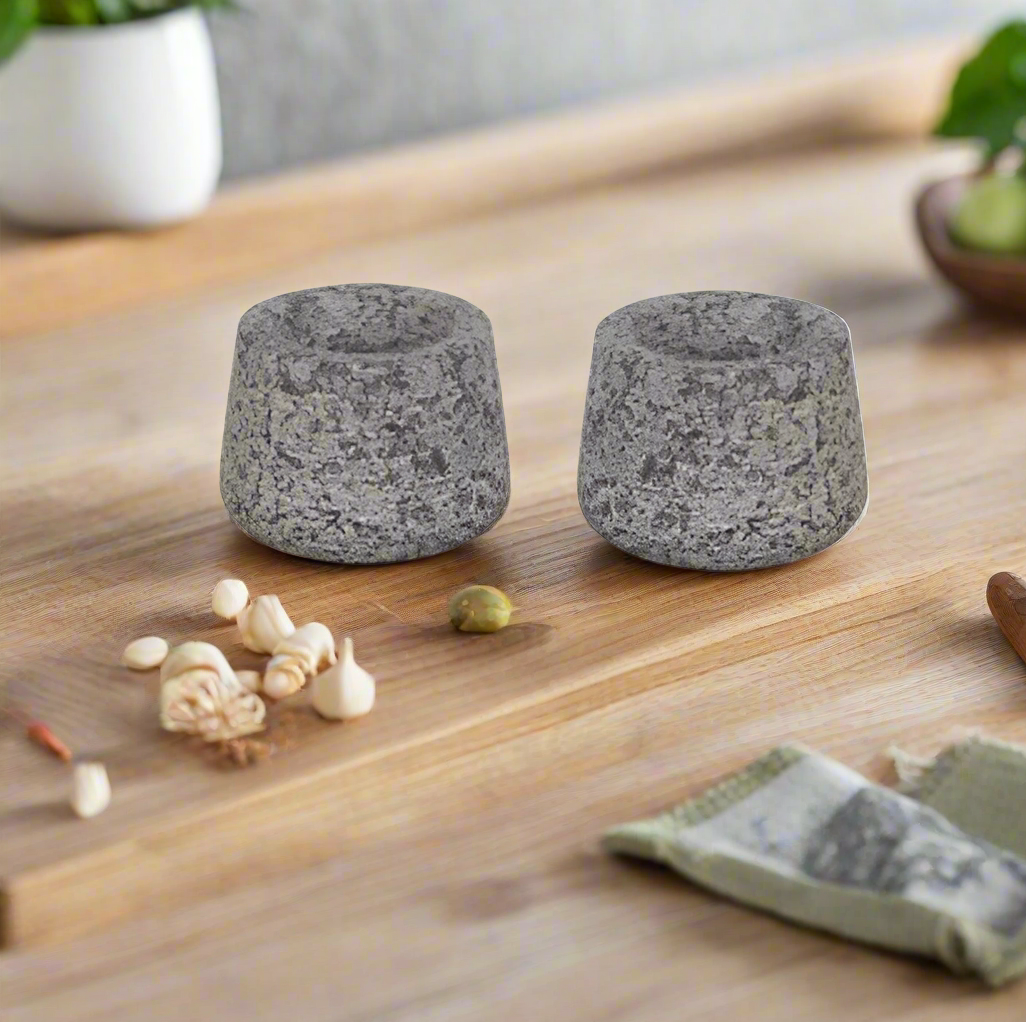 Two grey stone candle holders on a white background