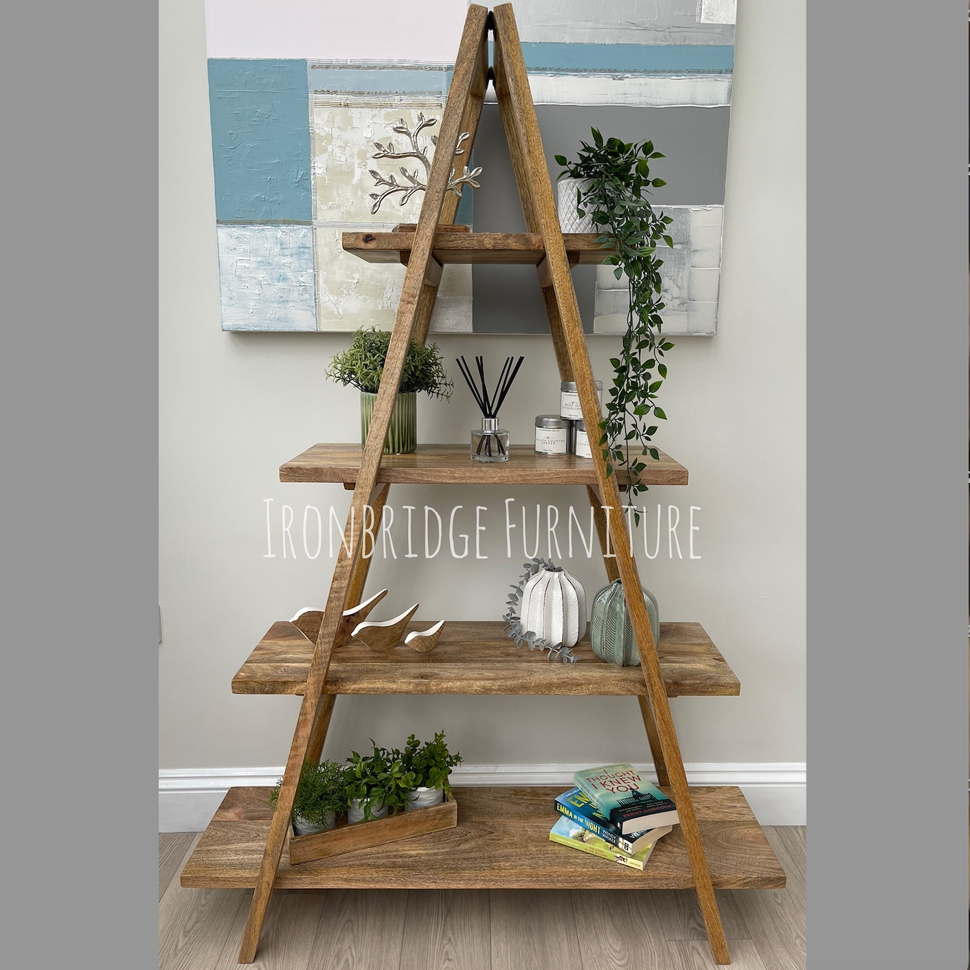 A-frame folding Mango wood 5 part bookcase in living room with items on.