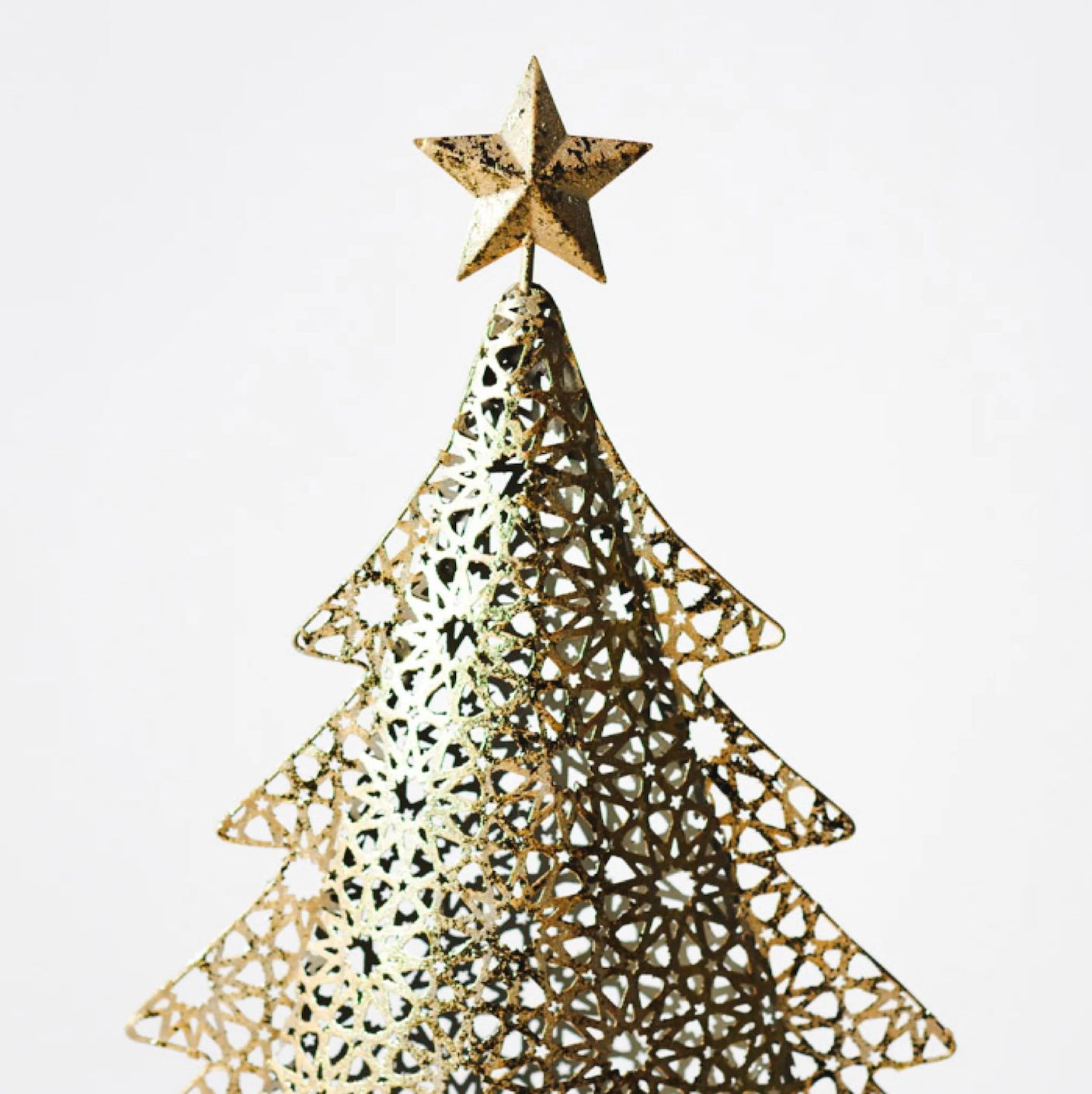 Gold metal Christmas tree on wood log base. One size shown with a focus on the star.