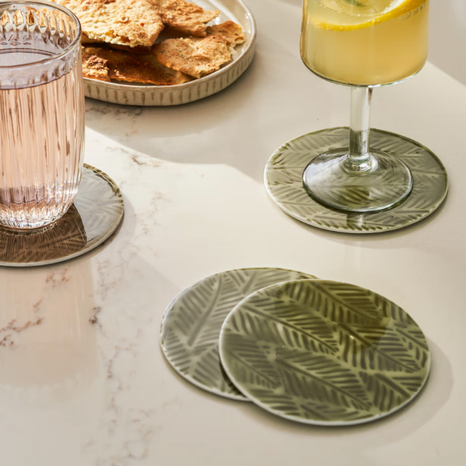 Set of 4 metal coasters being used at a summer meal.