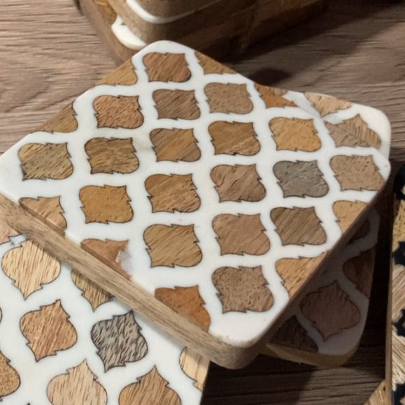 Set of 4 resin coasters with Mango wood inlay and base. Close up of white design
