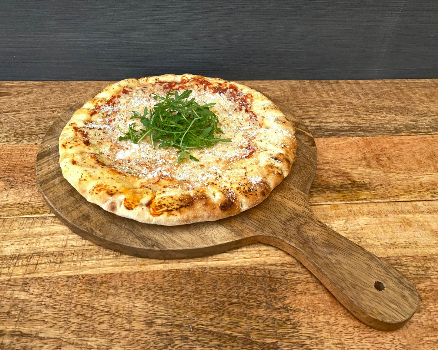 Mango wood pizza paddle board 14, 11 or 10 inch wide, shown with pizza