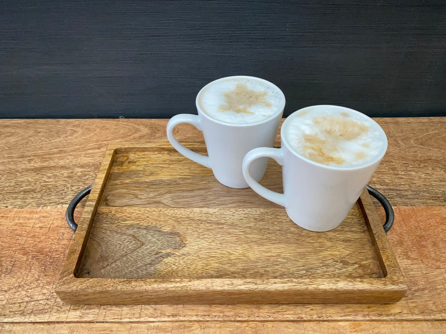 Mango wood mini tray with iron handles holding two white cups