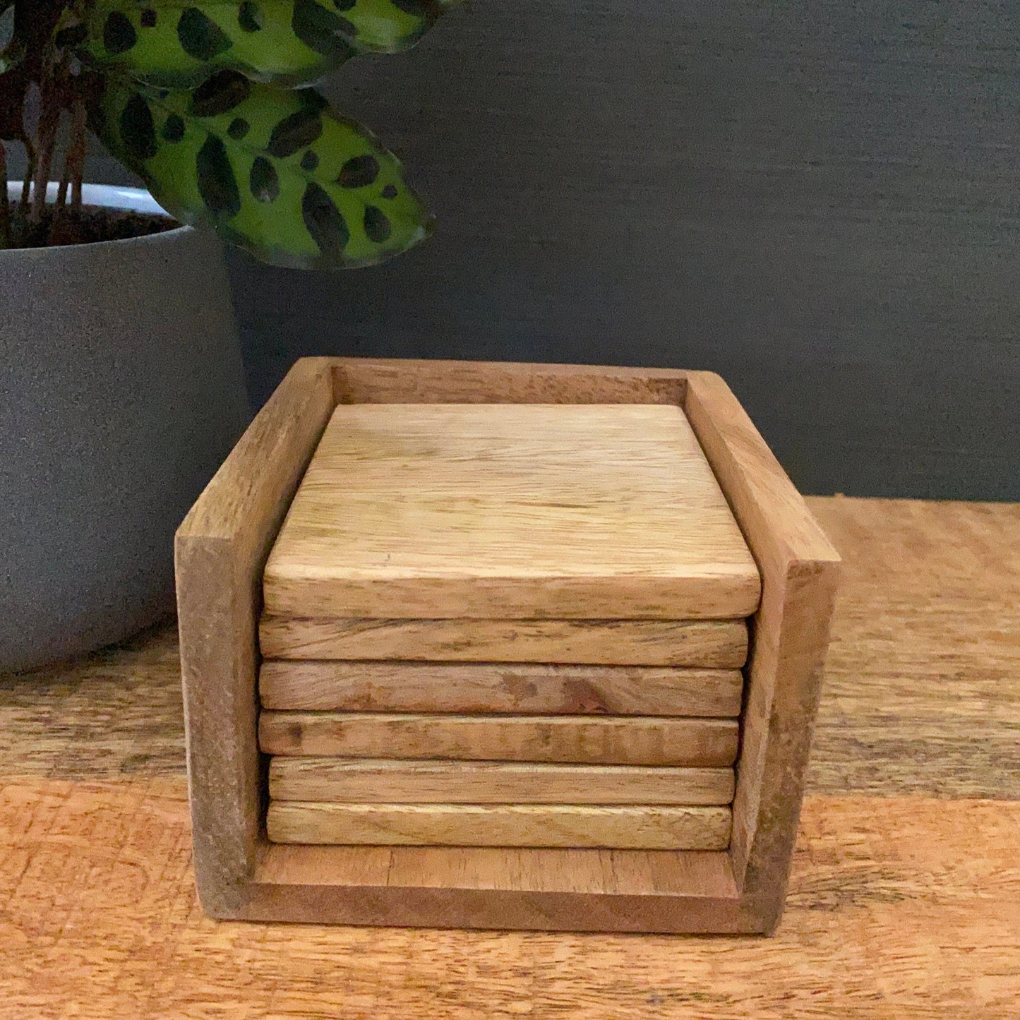 Set of 6 solid Mango wood square coasters with holder. Front view.