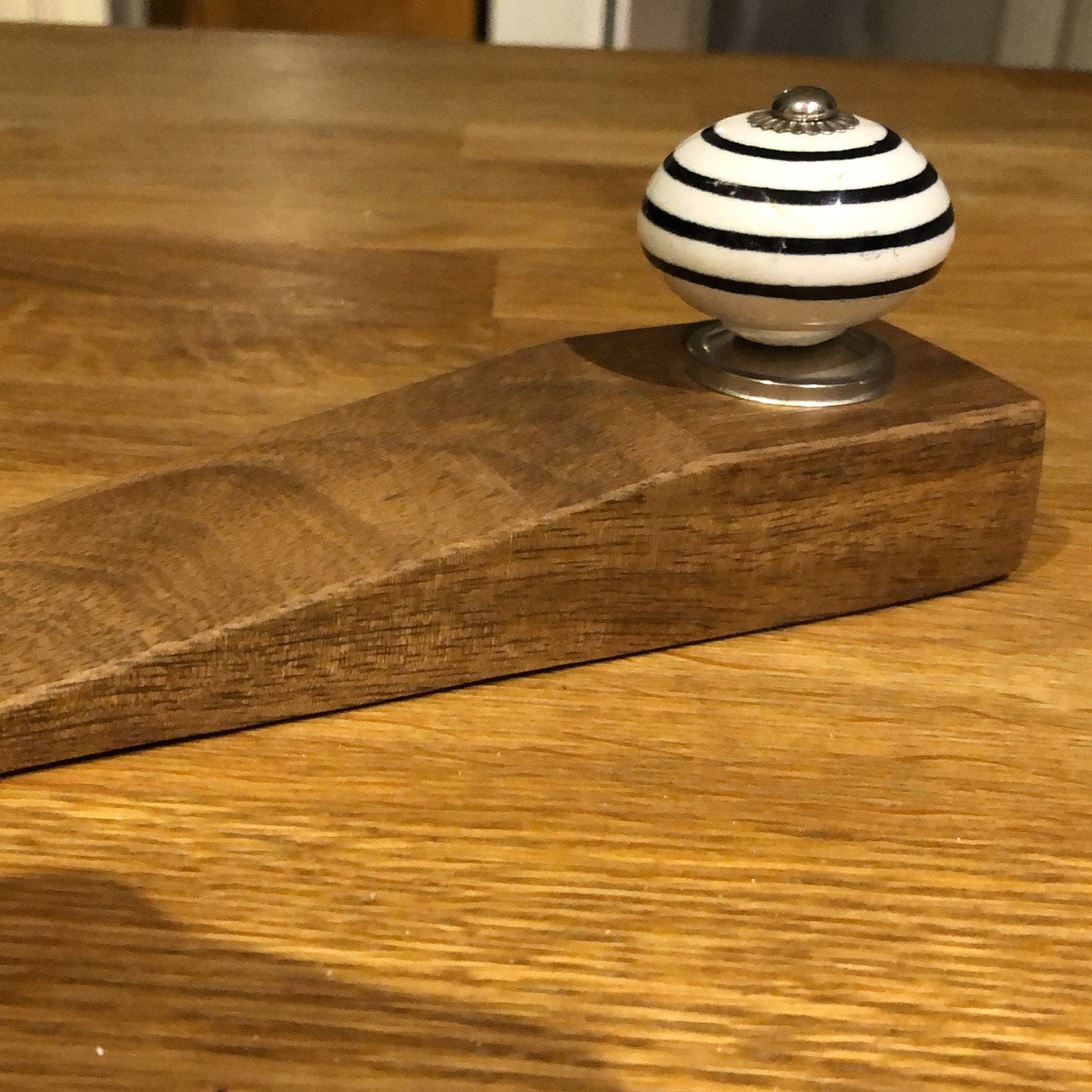 Mango wood door stop wedge. With or without ceramic knob handle. Single from a side angle.