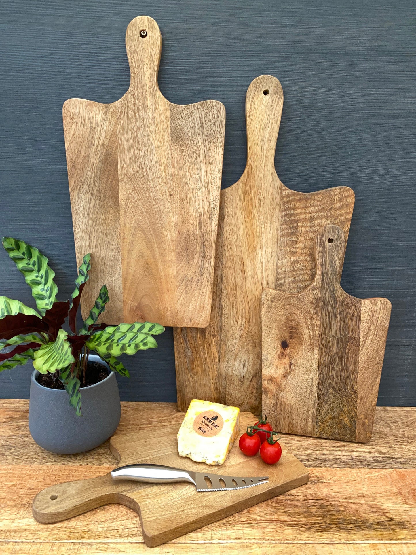 Solid Mango wood food serving paddle boards - Available in 3 sizes. Displayed with cheese and fruits.