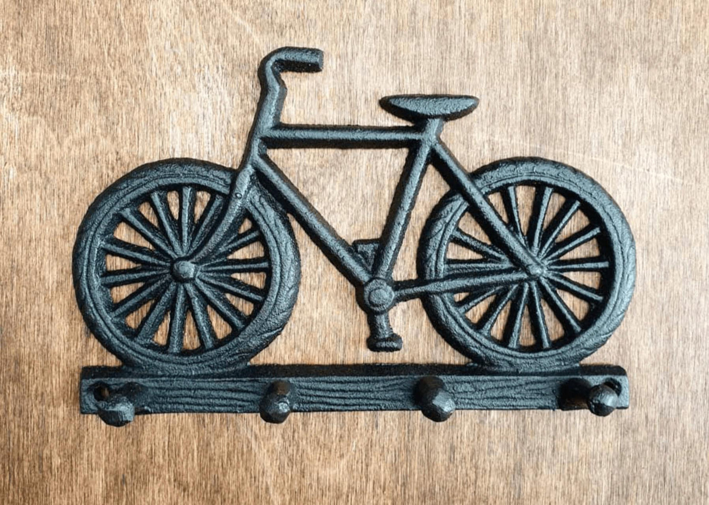 Black painted cast iron bike design set of hooks. On table.