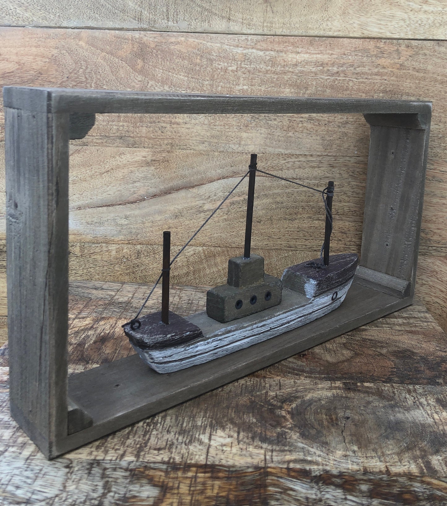 Rustic wood framed boat - shelf sitting decoration. At an angle.