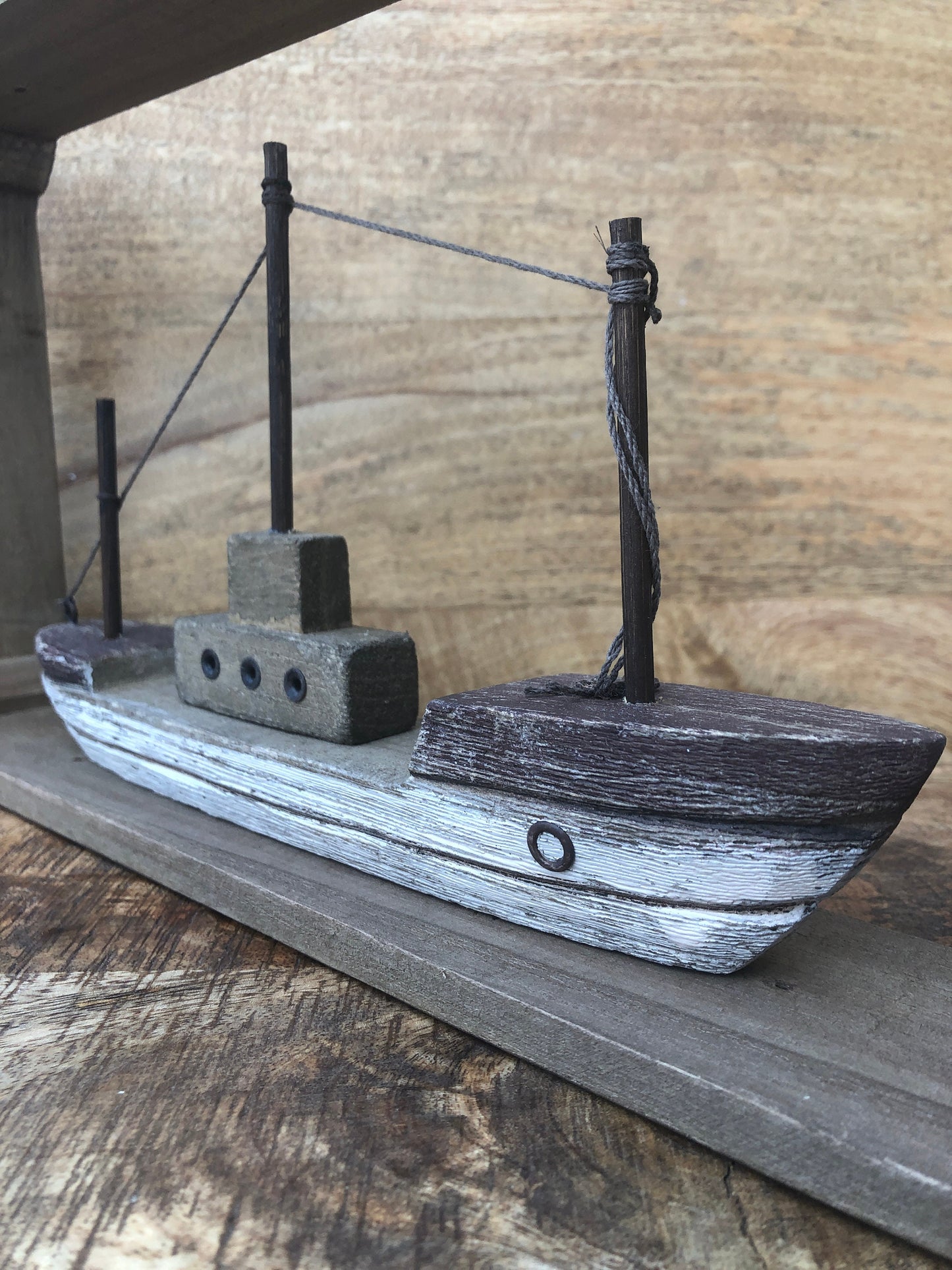 Rustic wood framed boat - shelf sitting decoration. Close up of boat.