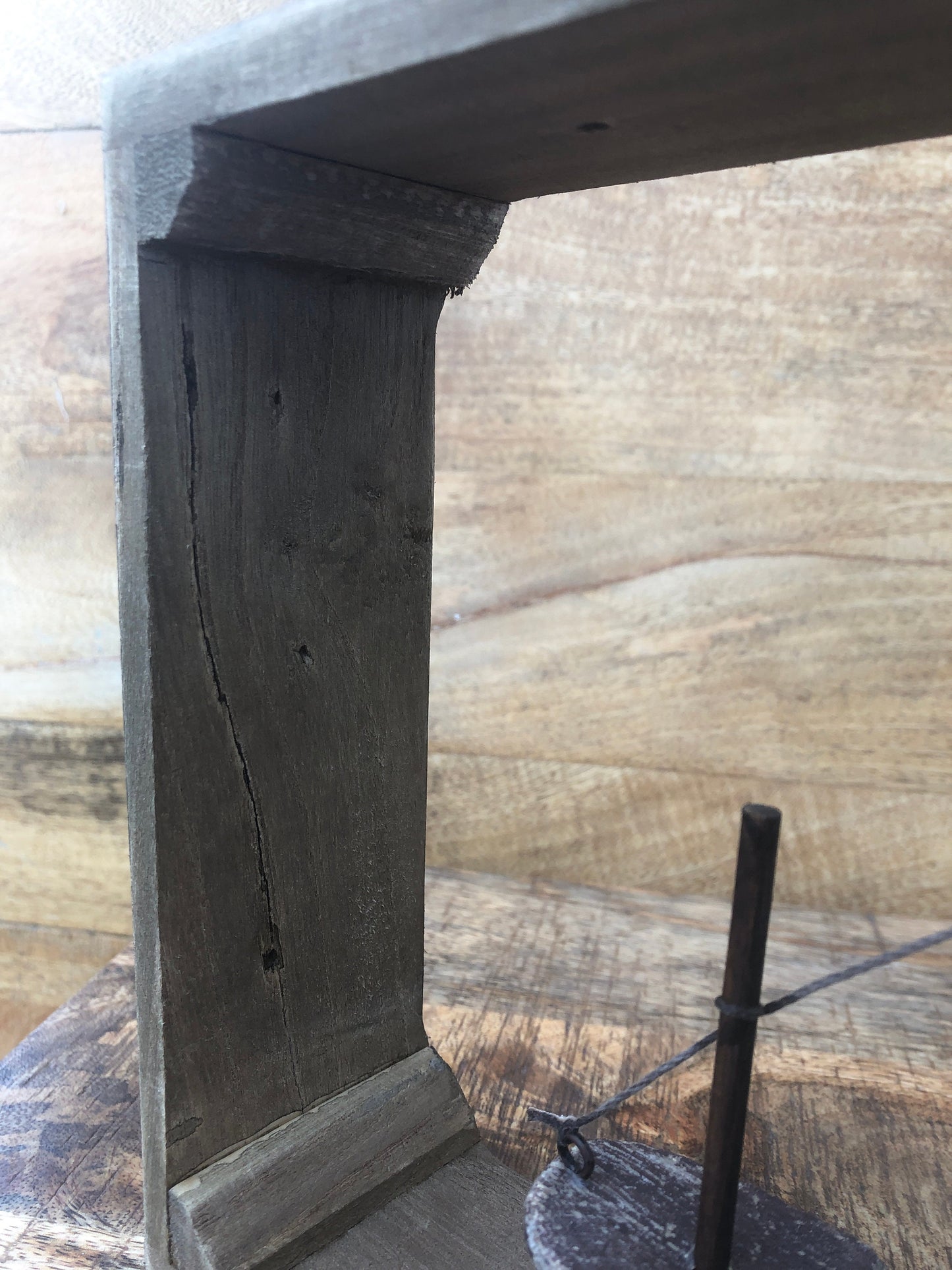 Rustic wood framed boat - shelf sitting decoration. Close up of frame.