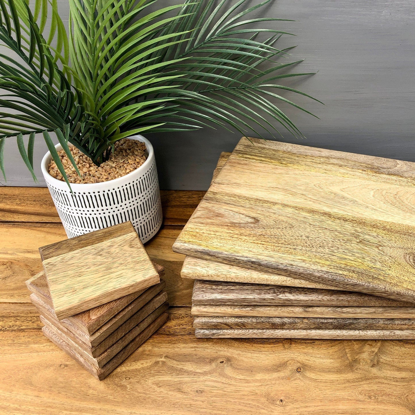 Set of Solid Mango Wood Board Placemats and Coasters. Coasters and placemats stacked separately.