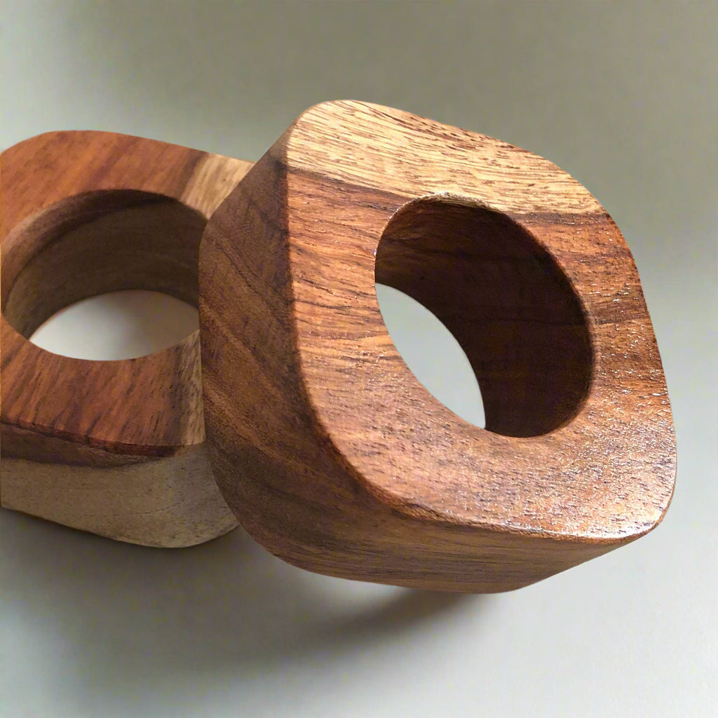 Set of solid Sheesham wood napkin rings. 2 rings leaning on each other.