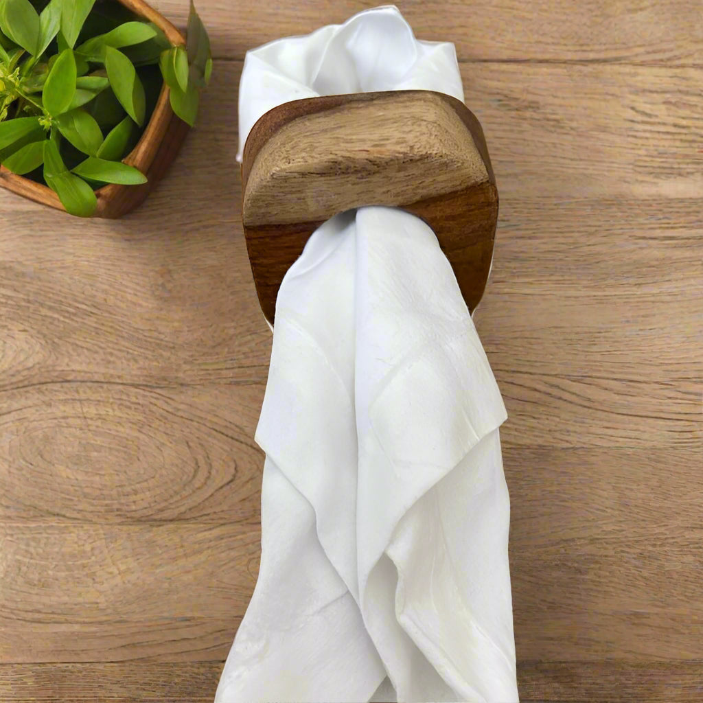 Set of solid Sheesham wood napkin rings with napkin in the middle.