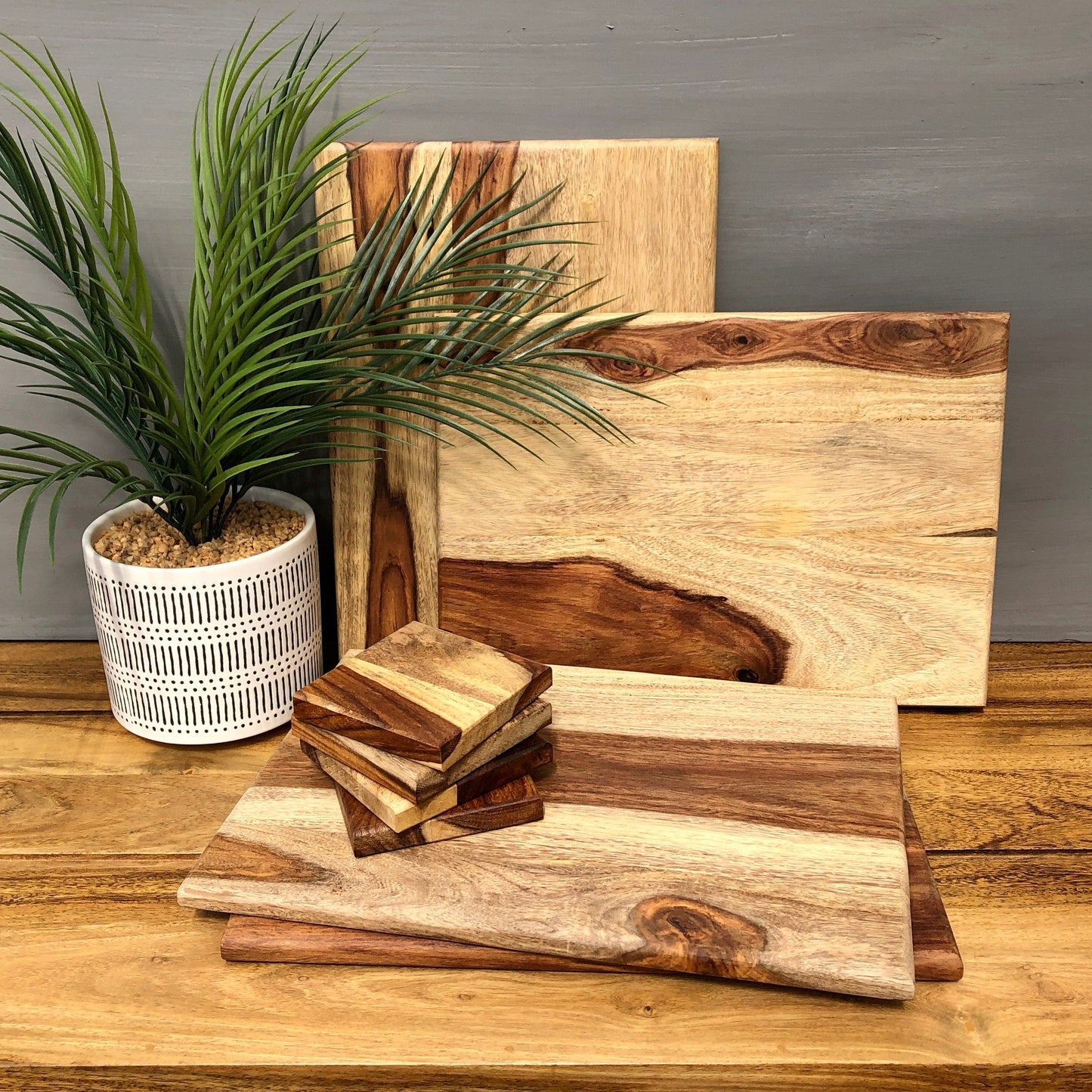 Set of Solid Natural Sheesham Wood Board Placemats & Coasters Placemats stacked with coasters.