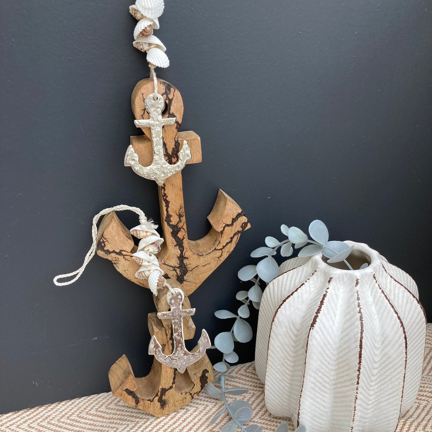Set of 2 decorative hanging Mango Wood anchors. Hanging next to vase.