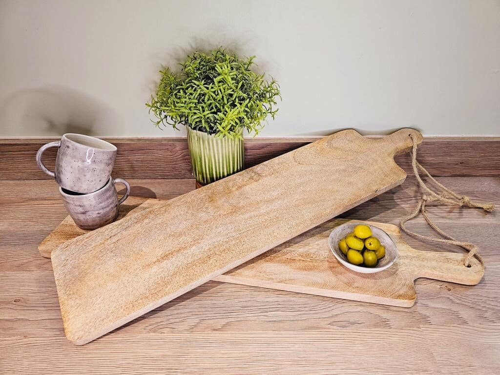 Long slim Mango wood paddle grazing board on a worktop