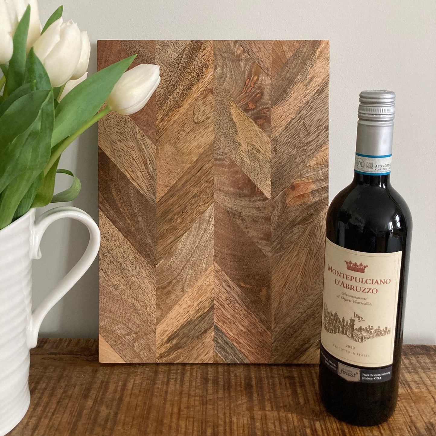 Set of solid Mango wood Parquet placemats alongside a bottle of wine