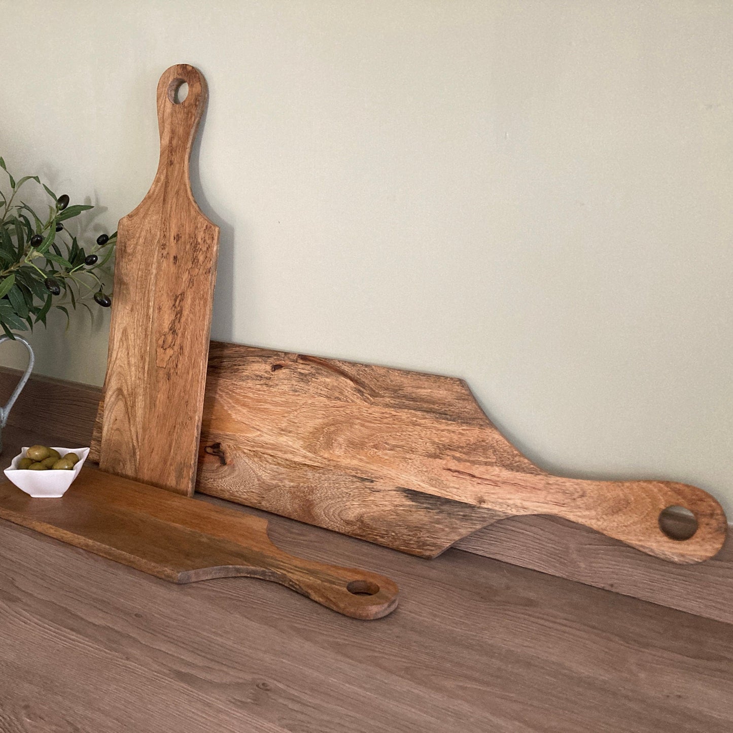 Mango wood loop handled paddle boards laying down on worktop