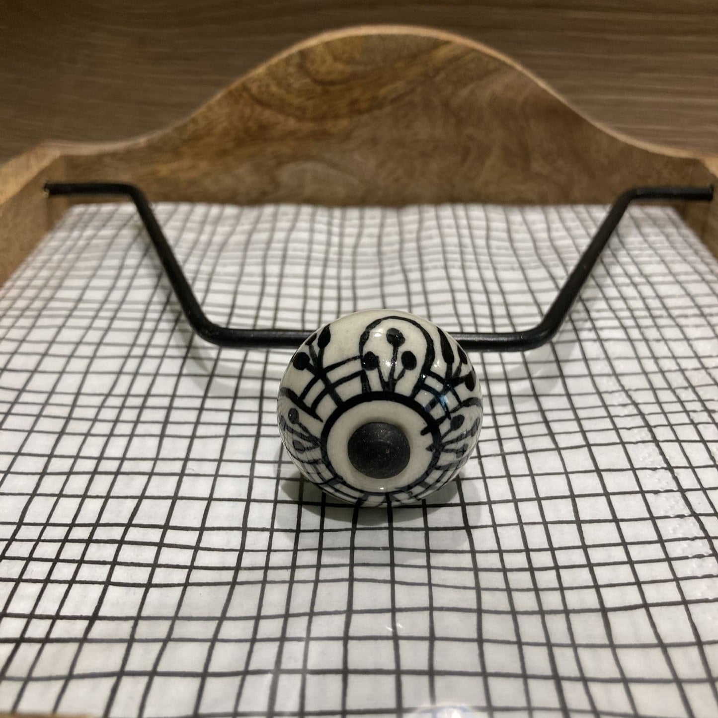 Mango wood napkin holder with ceramic knob weight - close up of black and white knob.